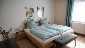 Ein Doppelbett mit einer Bank, einem Nachttisch und einem Beistelltisch.