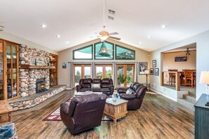 Cozy living area with a central fireplace, comfortable seating, and a large window offering a view of the outdoors.