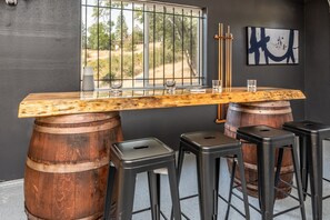 Relax with a drink at the bar, where a rustic wooden surface meets a unique barrel base and comfortable seating for all.