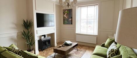 TV connectée, cheminée, livres, chaîne hi-fi