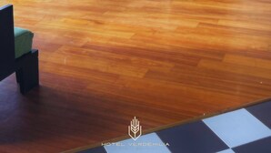 Un hall d’hôtel doté d’un plancher en bois, de sièges verts et de grandes œuvres d’art encadrées qui ornent les murs.
