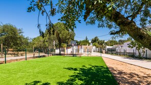 A well-maintained outdoor area with a green lawn, a basketball court, and a fenced play area. - Private Vale do Lobo resort with soccer pitch for 51 people (Almancil)