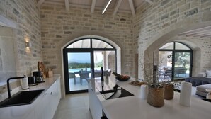 Una cocina moderna con una isla grande, un comedor con vistas y una zona de estar acogedora con chimenea.