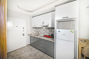 Departamento estándar | Cocina privada | Refrigerador con congelador, parrilla de estufa y utensilios de cocina