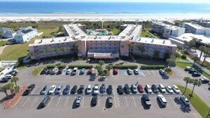 A hotel with a central courtyard, multiple parking lots, and a view of the ocean. - Beach and Tennis 118 - Updated Ground floor unit with screen porch and easy (St. Augustine Beach)