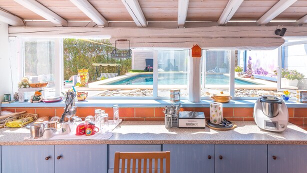 A kitchen with a view of a pool, a coffee maker, and a kettle. - Villa 'Casa Vacanza Cristina' with Private Pool, Terrace, and Wi-Fi (Plemmirio)
