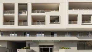 A modern multi-story building with balconies, a gated entrance, and a covered area. - GuestHost - Trastevere Modern Flat with Terrace (Roma)
