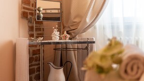 Une salle de bain avec un miroir, un porte-serviettes, un lavabo et un vase de fleurs.