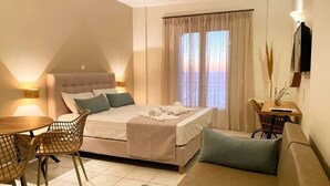 A modern hotel room with a bed, a dining table, and a sofa. - Apartment in a Hotel 'Sunset Premium Studio 9' with Sea View, Shared Pool, & Wi-Fi (Lefkada)