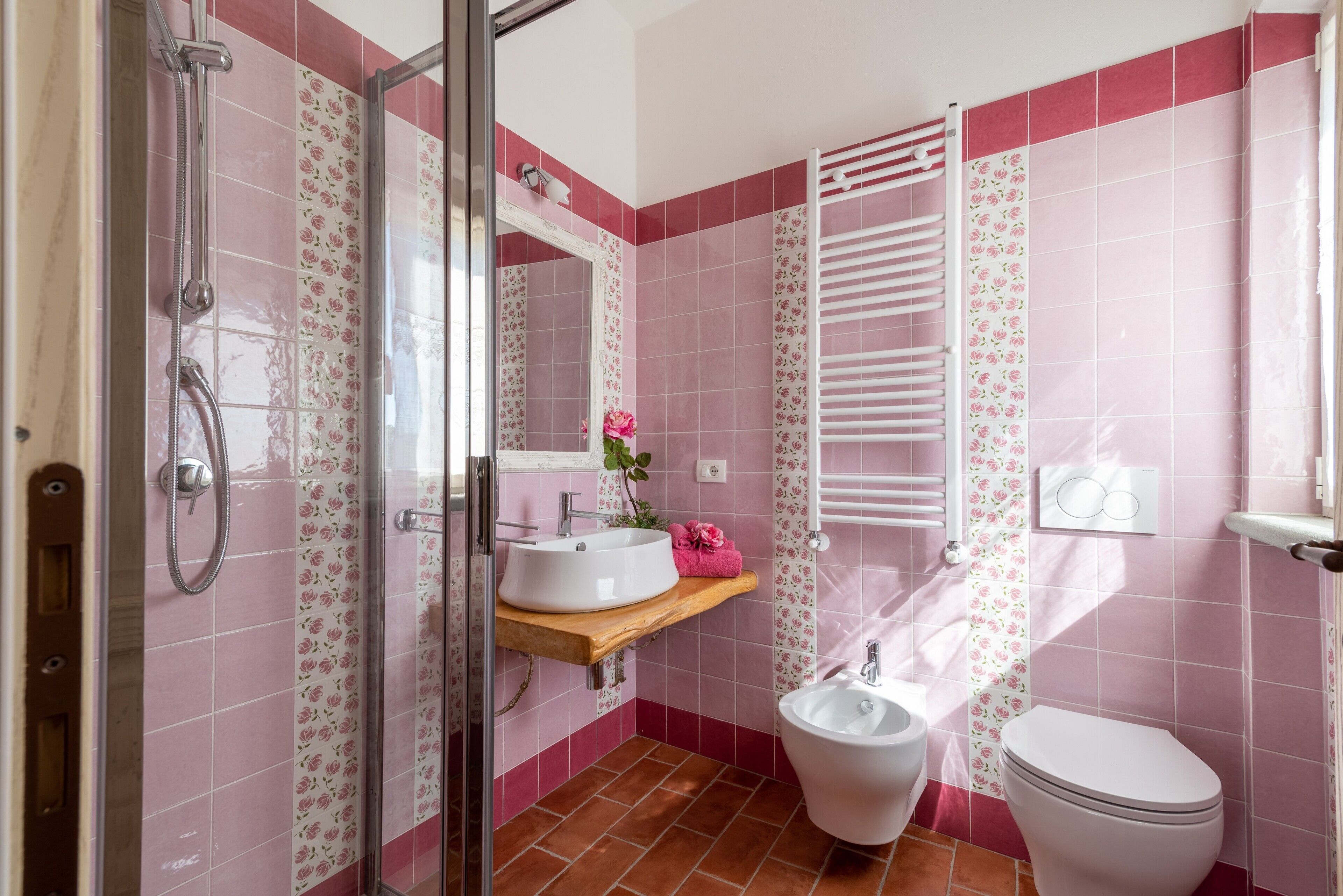 Ein Badezimmer mit Dusche, Waschbecken, Toilette und Handtuchhalter.