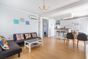 Un salon moderne comprenant un canapé, une table basse et un coin repas avec des chaises et une table.