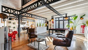 A spacious loft with exposed beams, a dining area, and a kitchen. - 'Villa la Forge Expérience Bien-Être' with Pool & Wi-Fi (Nuaillé-d'Aunis)