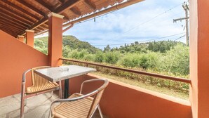 A covered outdoor area with a table and chairs, overlooking a hilly landscape. - Studio "Arianna Studio Ground Floor 5" with Sea View, Shared Pool & Wi-Fi (Corfu)