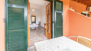 An open doorway leading to a room with a bed, a chair, and a table. - Studio "Arianna Studio Ground Floor 5" with Sea View, Shared Pool & Wi-Fi (Corfu)
