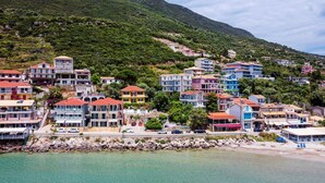Une ville côtière avec des immeubles à plusieurs étages, un littoral rocheux et une montagne en arrière-plan.