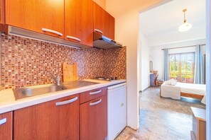 A kitchen with wooden cabinets, a sink, and a tiled backsplash.