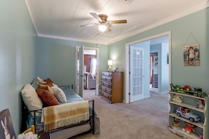 A child's bedroom with a bed, dresser, and toys.