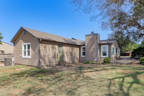 A two-story house with a front porch, a chimney, and a small front yard.