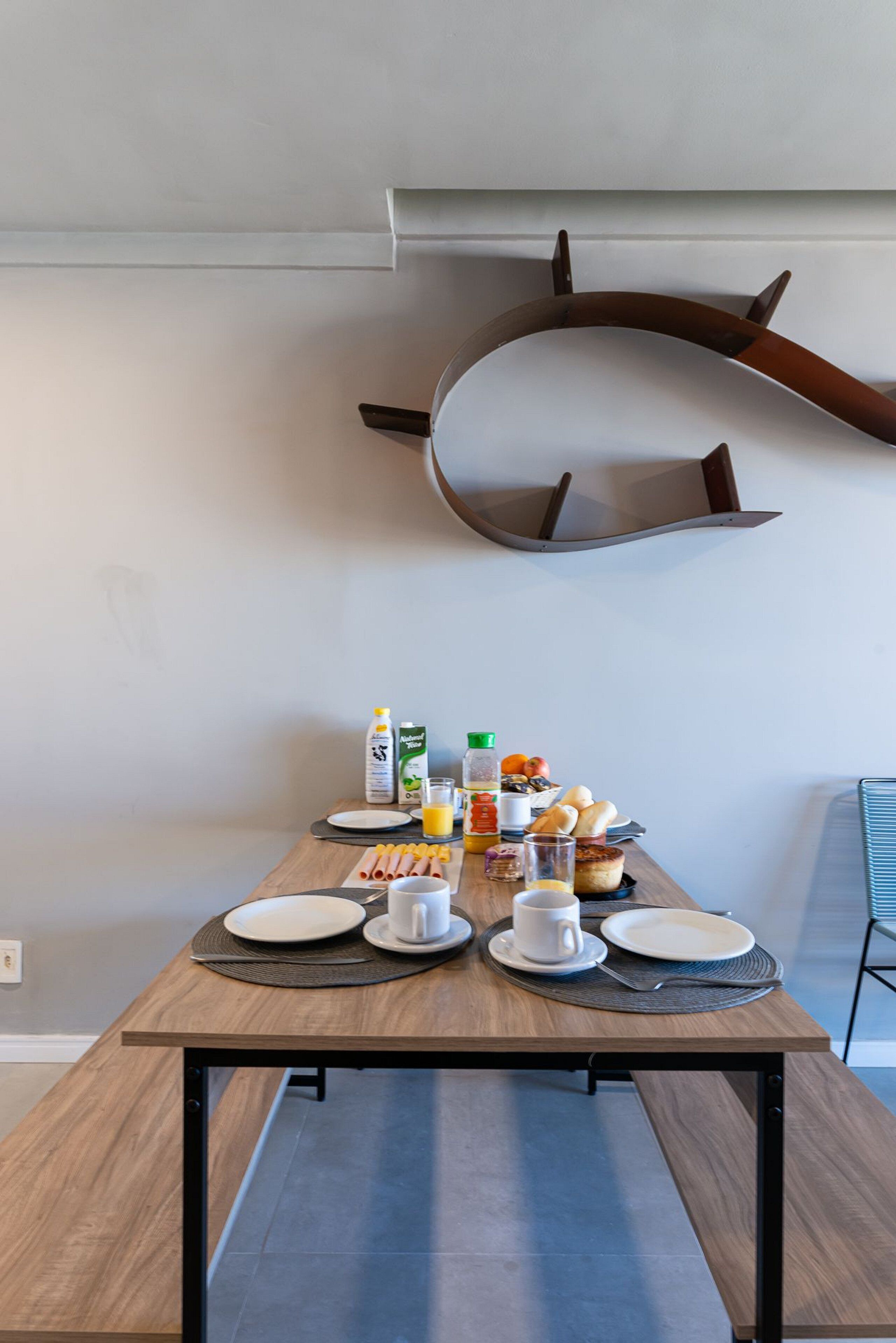 Une table à manger dressée avec des assiettes, des tasses et de la nourriture.