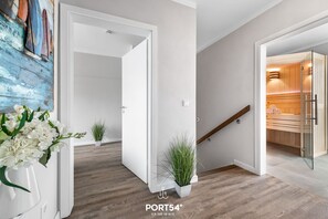 Enter a serene space with a cabinet, wooden floor, and staircase.