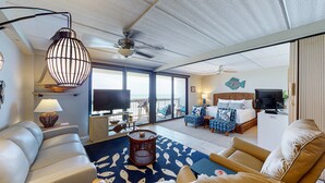 Une chambre d’hôtel spacieuse avec un balcon, un grand lit, un bureau avec un ordinateur et une télévision.
