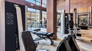 A modern gym with various exercise equipment, large windows, and a spacious layout. - Boulevard Stays Elegant 1BR Pool, Gym, Parking (Richardson)