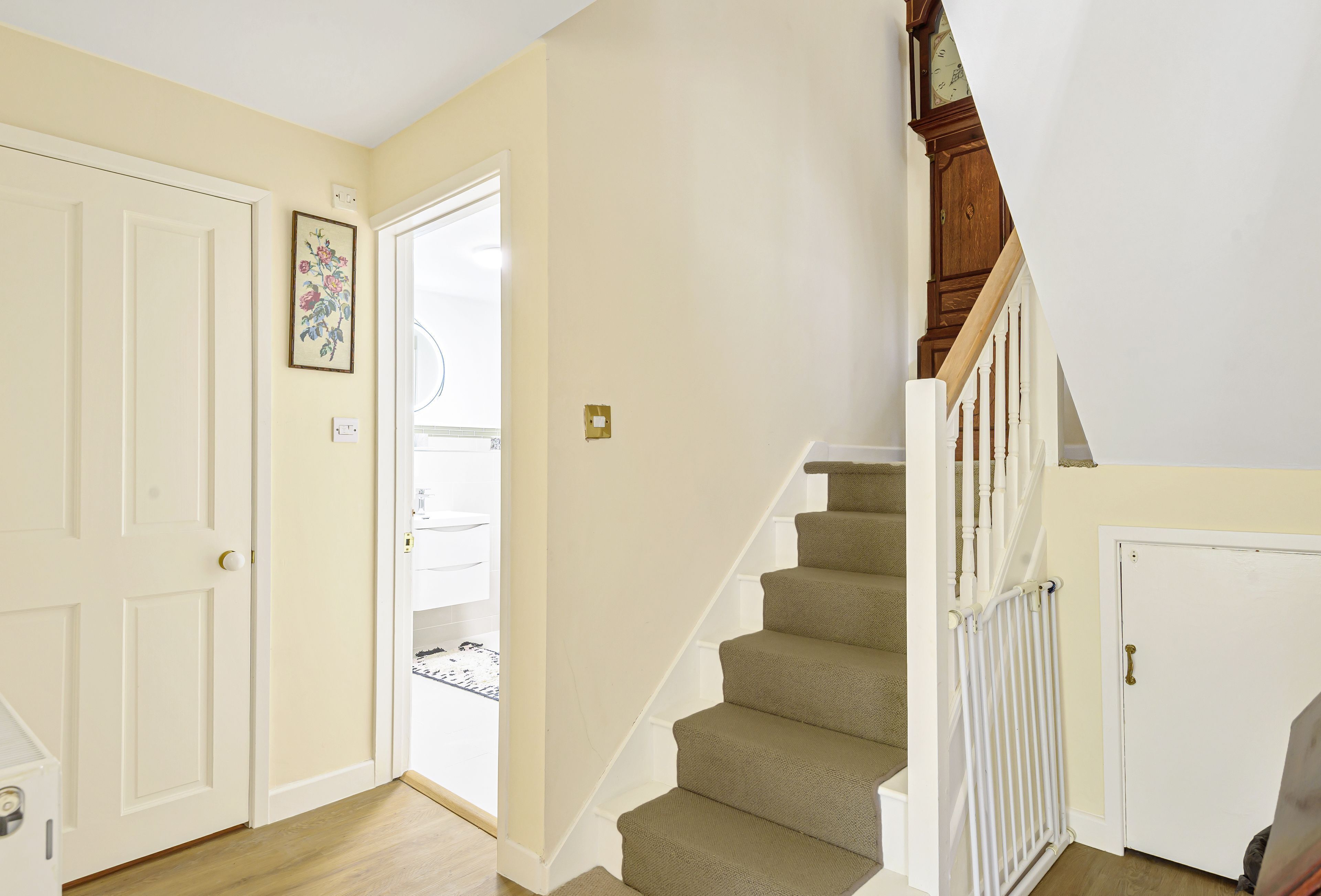 A staircase with beige carpet and white railings leading to a second floor.