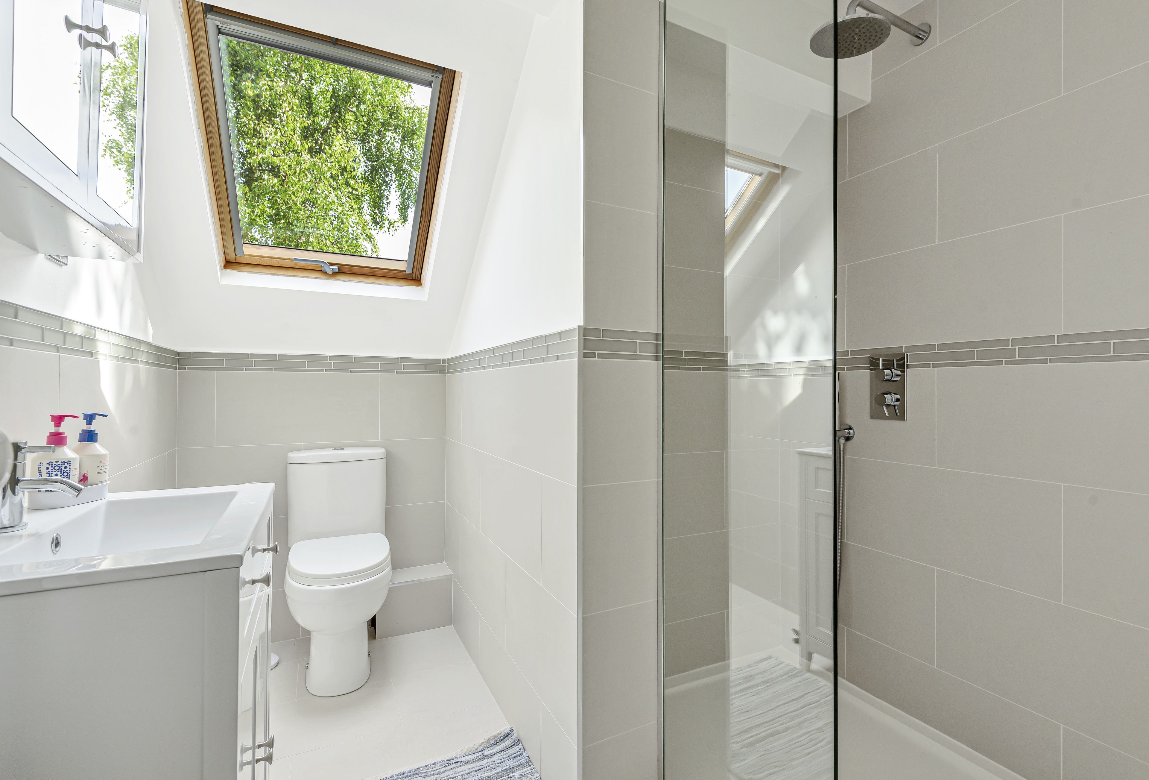 Une salle de bain avec des toilettes, un lavabo et une douche.