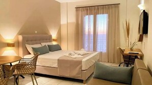 A bedroom with a bed, a sofa, a dining table, and chairs. - Apartment in a Hotel 'Sunset Premium Studio 5' with Sea View, Shared Pool, & Wi-Fi (Lefkada)