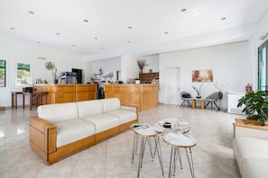 Un grand espace de vie comprenant un canapé, une table basse et une cuisine à l’arrière-plan.