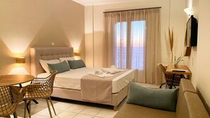 A hotel room with a bed, a sofa, a dining table, and a TV. - Apartment in a Hotel 'Sunset Premium Studio 3' with Sea View, Shared Pool, & Wi-Fi (Lefkada)