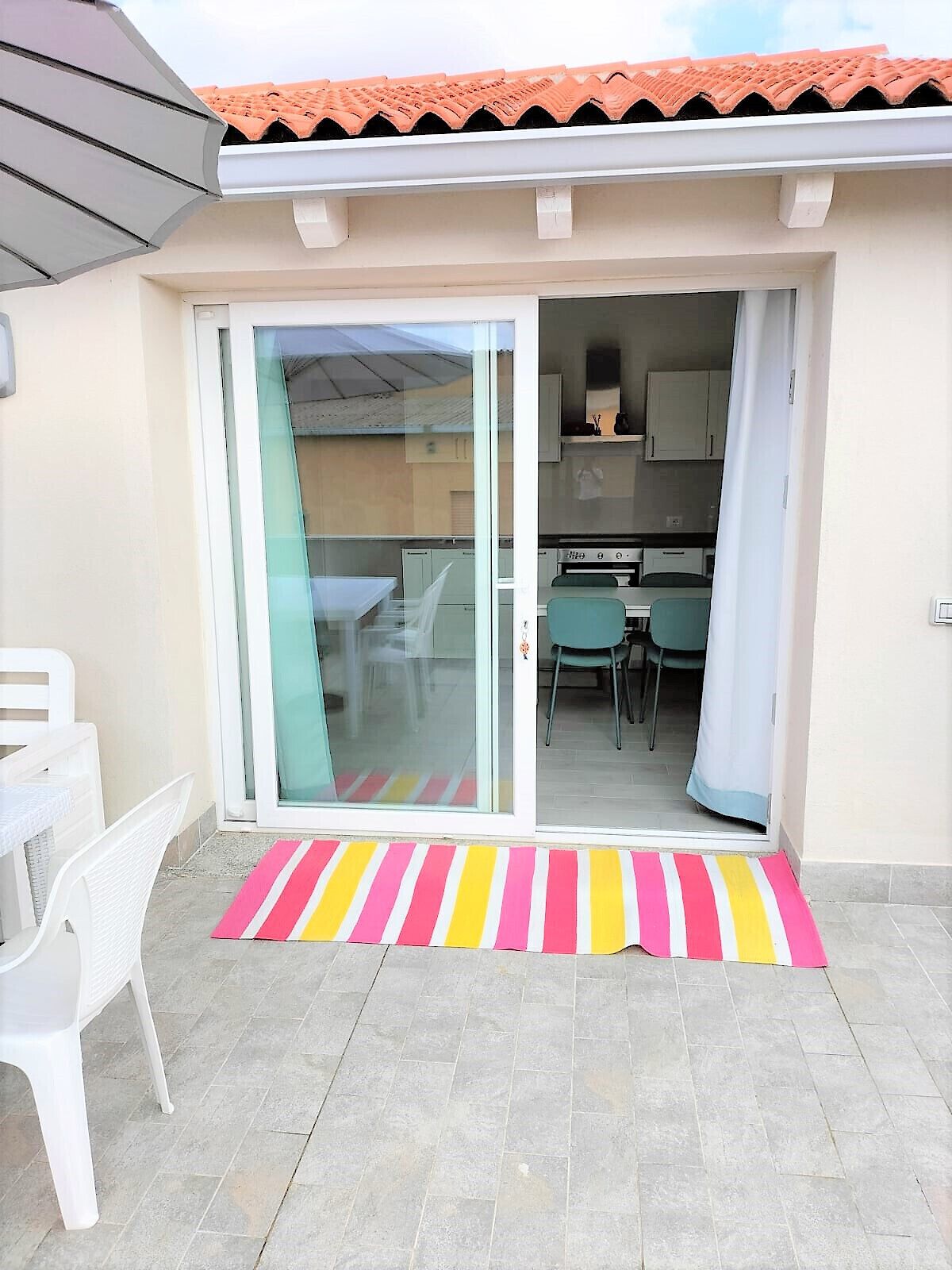 A small, enclosed patio area with a sliding glass door leading to a kitchen and dining space.