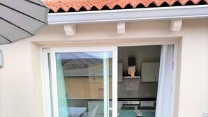 A small, enclosed patio area with a sliding glass door leading to a kitchen and dining space. - Affittimoderni Castelsardo La Gemma (Castelsardo)