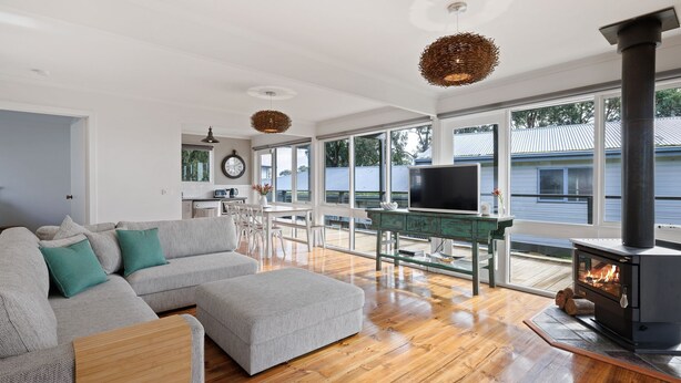 En moderne stue med en stor sofa, et fjernsyn og en brændeovn.