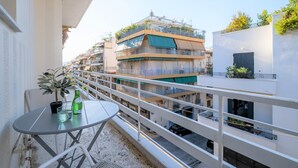 A balcony with a table, chairs, and a potted plant. - Luxury Penthouse in prime central Athens Thissio (Athina)