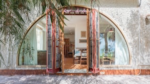 Una entrada de edificio con un gran arco, piso de baldosas y vista al interior.
