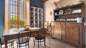A dining area with a wooden table, chairs, a bookshelf, and a cabinet with dishes. - 'La Ripa - Apartment I Ghiri' with Shared Pool & Wi-Fi (San Gimignano)