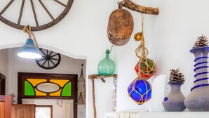 Een landelijk interieur met een hangende houten emmer, een groene fles en decoratieve bolvormen.