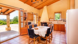 Een keuken met een eettafel, stoelen en uitzicht op de omgeving.