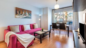Ein modernes Wohnzimmer mit Sofa, Couchtisch und Essbereich.