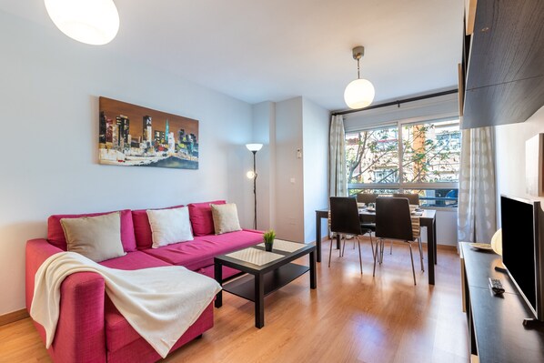 Un salon moderne avec un canapé, une table basse et un coin repas.