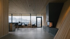 Ein modernes Interieur mit schrägem Dach, Kamin, Essbereich und Bergblick.