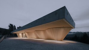 A modern building with a sloped roof and wooden paneling.