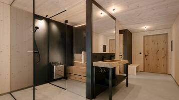 A modern bathroom with a glass shower enclosure, a wooden vanity, and a large mirror.