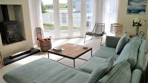 A living room with a sofa set, a wooden coffee table, a wicker basket, and a fireplace.