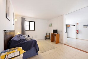 A room with a bed, desk, chair, and a television. - Apartment "A Cerca - E" with Shared Pool, Garden & Wi-Fi (Lagos)