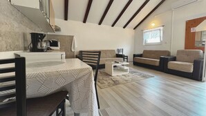 Een moderne woonkamer met een eethoek, een keuken en een trap.