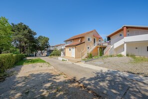 Een woonstraat met huizen, een verharde weg en een gazon.