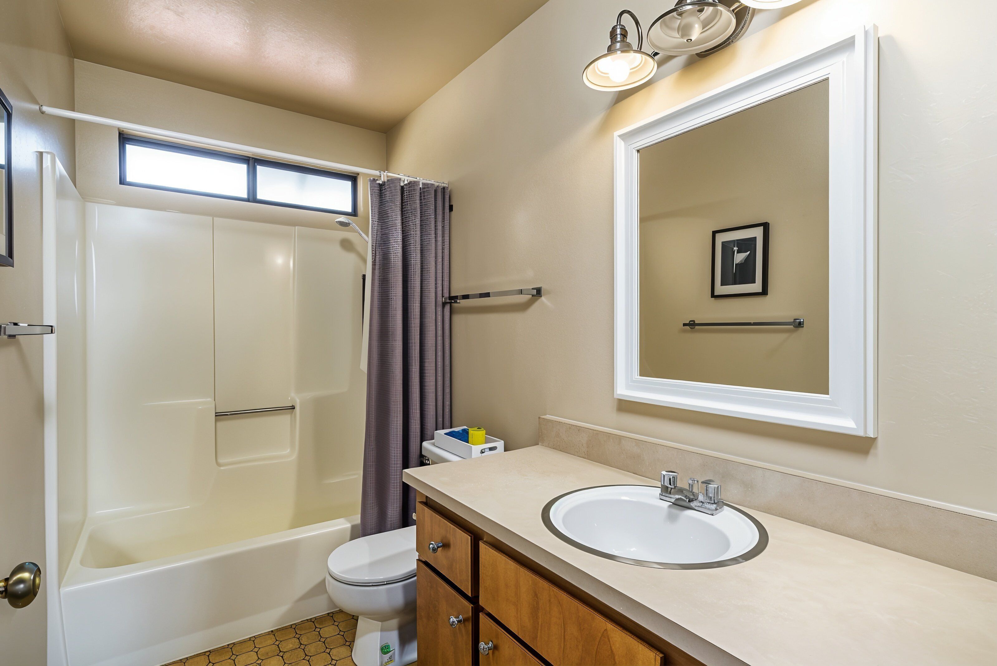 A bathroom with a bathtub, toilet, and sink.