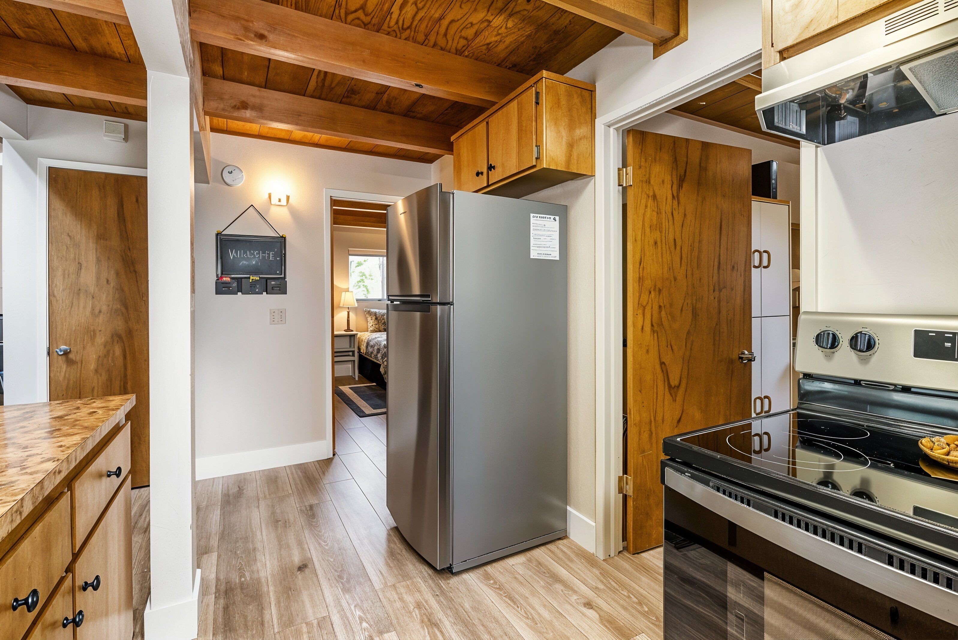 Une cuisine moderne avec des meubles en bois, un réfrigérateur en acier inoxydable et un four encastré.